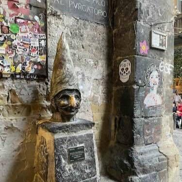 A Pulcinella bust on a street corner in the old centre of Naples