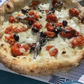 A Neapolitan pizza topped with tomatoes, anchovies and olives at Sorbillo